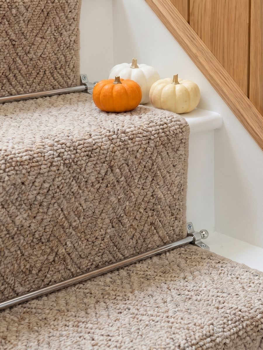 Chrome stair rods on a herringbone stair runner